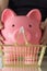 the man has a large piggy bank in his hands  a golden shopping basket stands on the table in front of them. The concept of saving