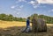 A man in a hat covered with straw looks in the field. Agricultural work. Harvesting of wheat.