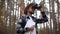 Man in a hat holds a map in and looks through binoculars while hiking