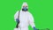 Man in a hazmat walking in and using disinfectant on a green screen, chroma key.