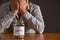 Man With Head In Hands Looking At Jar Labelled School Fees