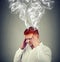 Man with head smoking from problems