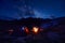 Man with headlamp near bon fire at night sky