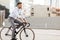 Man with headphones riding bicycle on city street