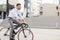 Man with headphones riding bicycle on city street