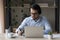 Man in headphones sit at desk holds pen noting information