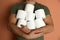 Man with heap of toilet paper rolls on brown background, closeup