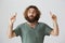 Man hears his favorite song playing by street band. Portrait of pleased handsome eastern man with beard and curly hair