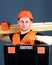 Man in helmet, hard hat holds toolbox and wooden beams, grey background. Professional woodworker concept. Carpenter