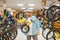 Man in helmet holds children`s bicycle, sport shop