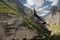 A man in a helmet jumps ropeup with an empty flag in the mountains. Extreme sports. Leisure