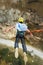 A man in a helmet jumps ropeup with an empty flag in the mountains. Extreme sports. Leisure. Top view