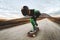 A man in helmet and a leather suit in a special rack rides a longboard on afsaltu on background mountains and beautiful