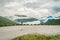 Man in helmet photographer taking photos back view of mountains landscape in rainy weather in Norway. Travel Lifestyle