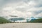 Man in helmet photographer taking photos back view of mountains landscape in rainy weather in Norway. Travel Lifestyle