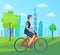 Man in Helmet Rides Bicycle through Green Park