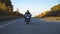 Man in helmet riding on a motorbike at autumnal highway. Motorcyclist driving his motorcycle on country road with