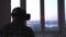 Man in a helmet of virtual reality against the background of a huge window in the office at the workplace.