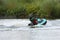 Man in a helmet and wetsuit performs tricks on a jetski