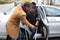 Man Helping Disabled Wife To Get Out Of A Car