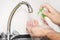 Man helping himself to dollop of antibacterial soap, close up of hands. Washing hands rubbing with soap man for winter flu virus