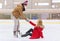 Man helping women to rise up on skating rink