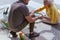 Man helps an elderly woman get up after falling off a bicycle on a suburban road