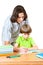 A man helps first graders how to write in a notebook