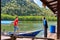 A man helps to moor a boat with tourists to a wooden pier