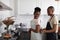 Man helps woman to tie an apron in kitchen