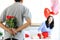 Man hiding beautiful red rose bouquet behind back, ready to give Valentine flower present to lover girlfriend for celebration,