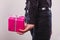 Man hiding pink gift box with ribbon behind back