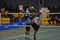 Man high kicking the ball through the net in game of Kick Volleyball, sepak takraw
