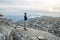 Man hiker admires the view of the landscape standing at the peak of the mountain. Goal achievement and active life