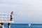 Man hiker with backpack on pier, sea landscape