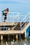 Man hiker with backpack on pier, sea landscape