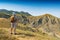 Man hiker with backpack standing against badland