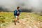 Man hiker climbing on mountain surrounded with clouds in Carpathians. Tired traveler with backpack resting