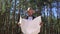 Man hiker consults a map in the forest. Composition hiking.