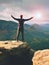 Man hiker in dark sportswear and poles stand on mountain peak rock. Exposed sandstone cliff