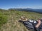 Man hiker in hat taking a nap at meadow with Mountain landscape of Western Tatra mountains or Rohace with view on high