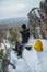 Man hiker have a rest at mountain top, drinking tea and eating during winter adventure.