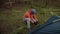 Man hiker sets up camping tent in the fall forest on backpacking expedition. Traveler setting an overnight tent in the