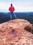 Man hiker on sharp cliff. Hiker climbed up to peak enjoy view. Man watch over morning valley