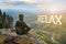 Man hiker sitting on top of mountain and contemplates beautiful view to the valley. Relax lettering in form of clouds.