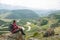 Man hiker sitting on top of mountain,  looking on beautiful panoramic landscape.