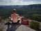 Man hiker sitting on the top of the mountain in yoga pose