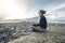 Man hiker sitting in a yoga pose at the peak of the mountain in the summer. Meditation after a long climb on a mountain