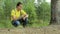 Man hiker walking through the forest and touch smart watch. Yellow T-shirt and jeans with suspenders. Technology in the