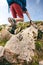 Man hiker walking on mountain rocks with sticks. Beautiful weather with Scotland nature. Detail of hiking boots on the difficult p